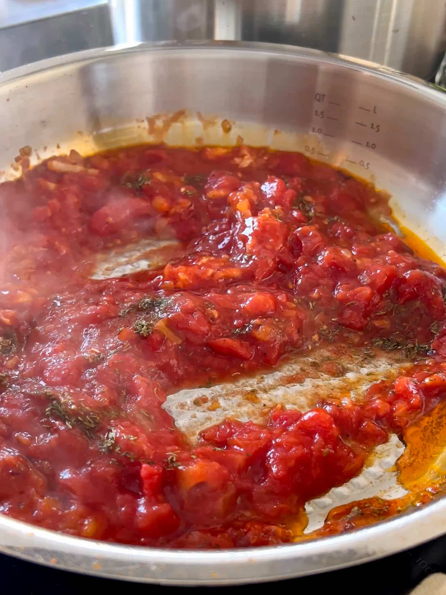 die rote Tomatensauce für rigatoni al forno wird in einer großen pfanne gekocht