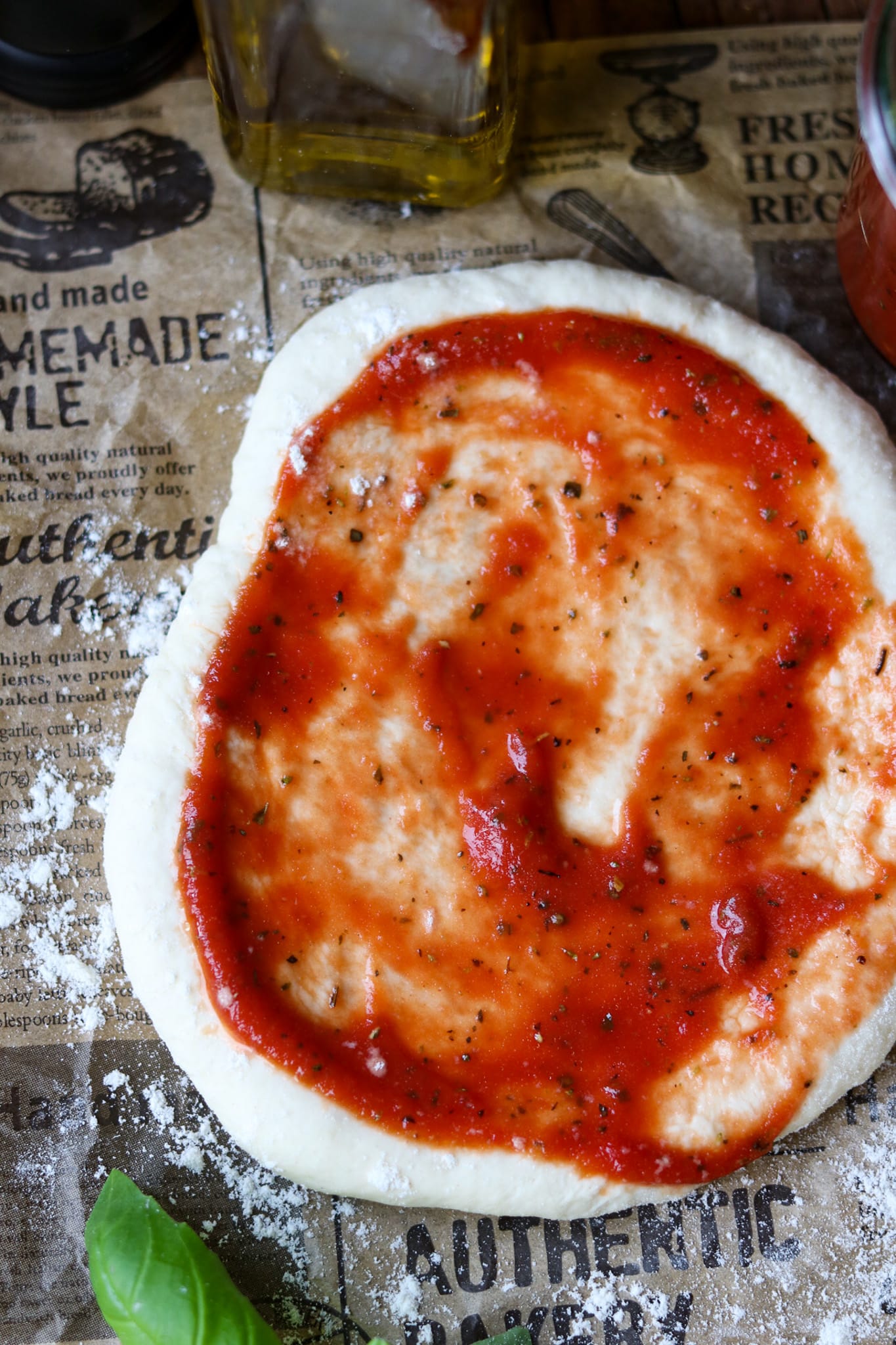 Pizzateig  selber machen – einfaches Rezept, Ausgerollter runder Teig mit frischer Tomatensoße