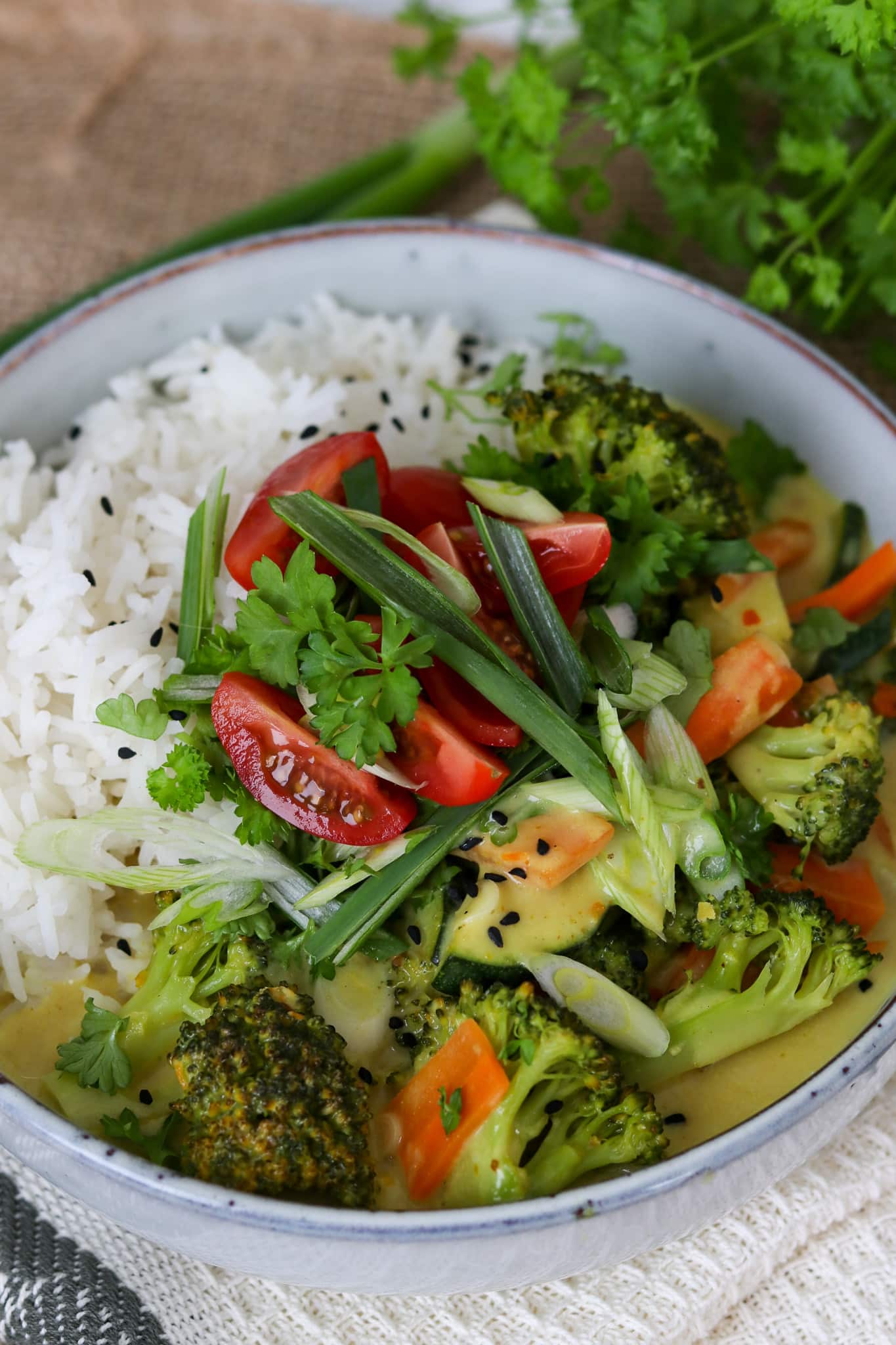 Einfaches Gemüse Curry mit Kokosmilch, Nahaufnahme der Schüsse in grau mit viel Gemüse in grün
