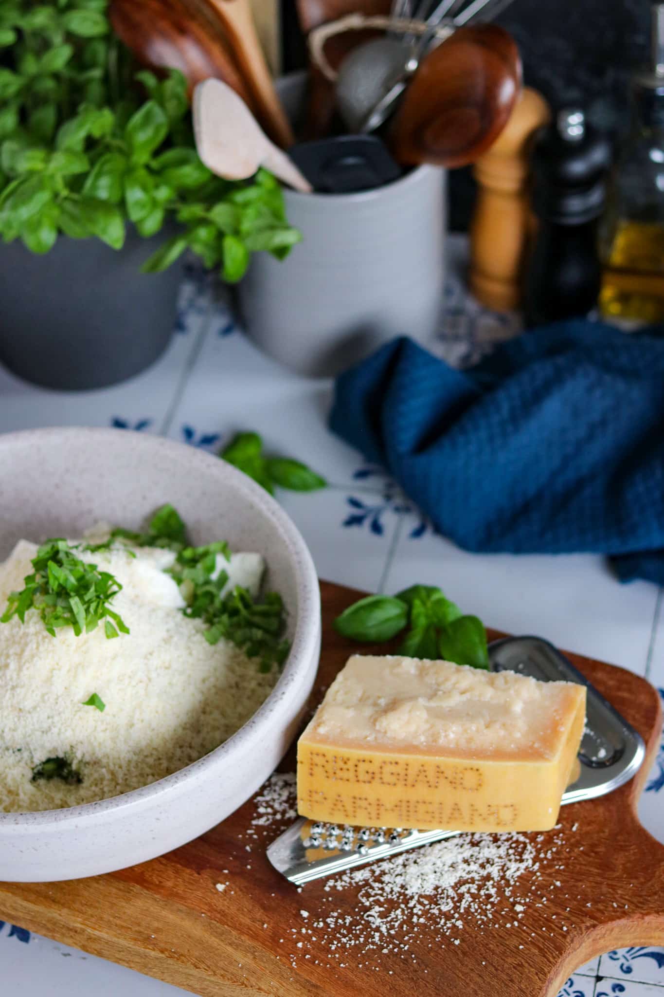 Ofen Zucchini Bratlinge – mit Ricotta, rohe Bratlingsmasse in einer Schale dazu ein großes Stück Parmesan