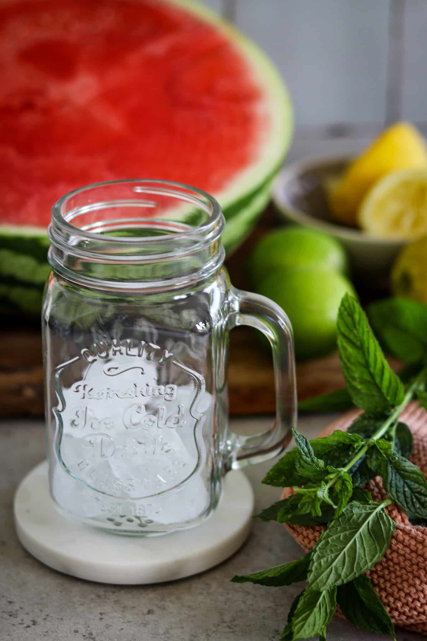 Wassermelonen Smoothie, ein leeres Glas mit frischer Minze und Eiswürfeln