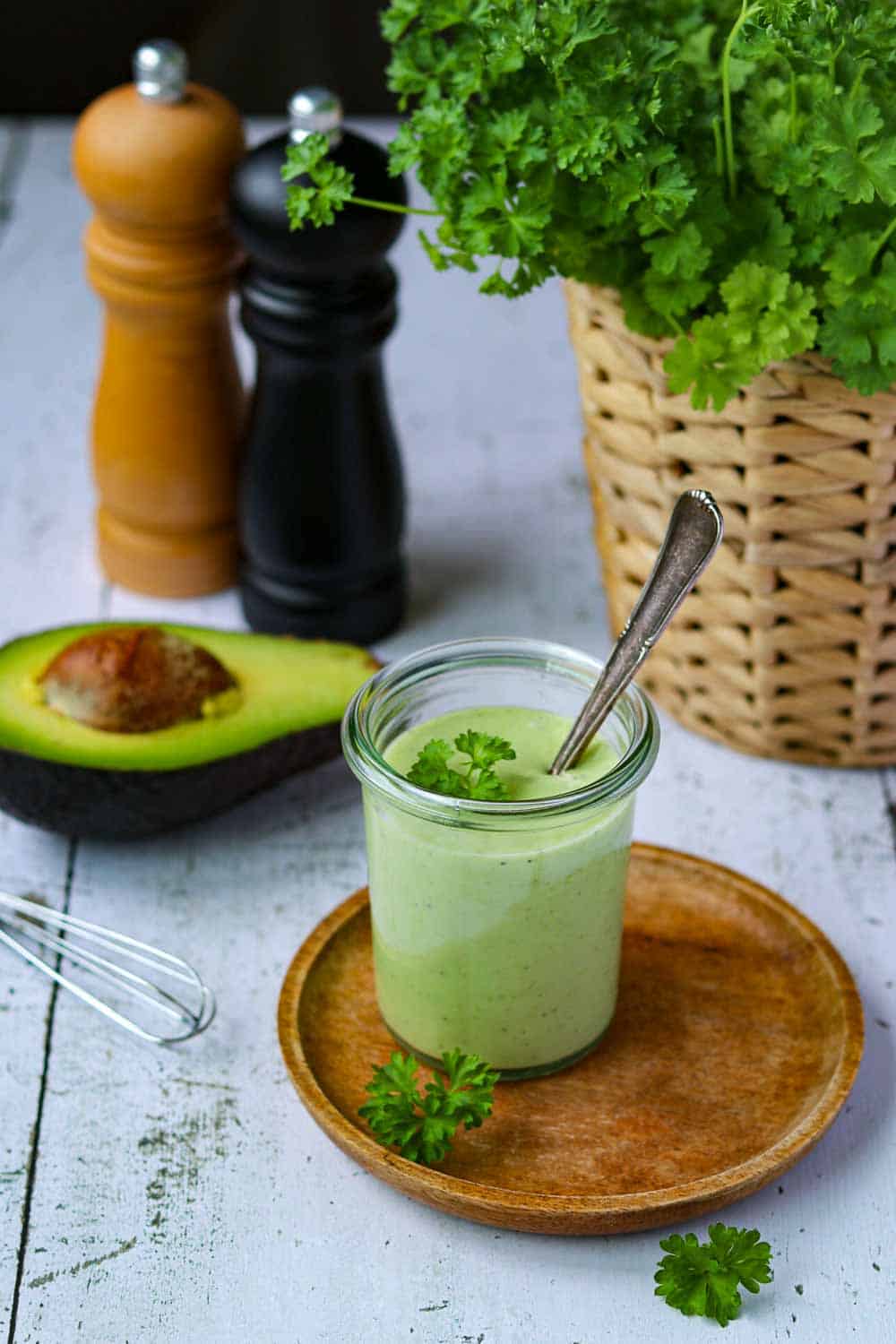 Leckeres Avocado Dressing für Salate & Bowls, in einem Glas auf dem Löffel das cremige Dressing in Grün