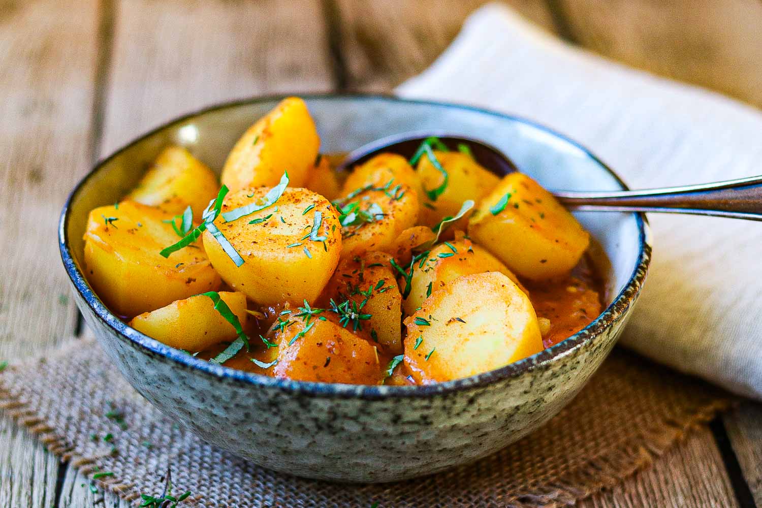 Kartoffelgulasch Rezept mit frischen Kräutern als Nahaufnahme 