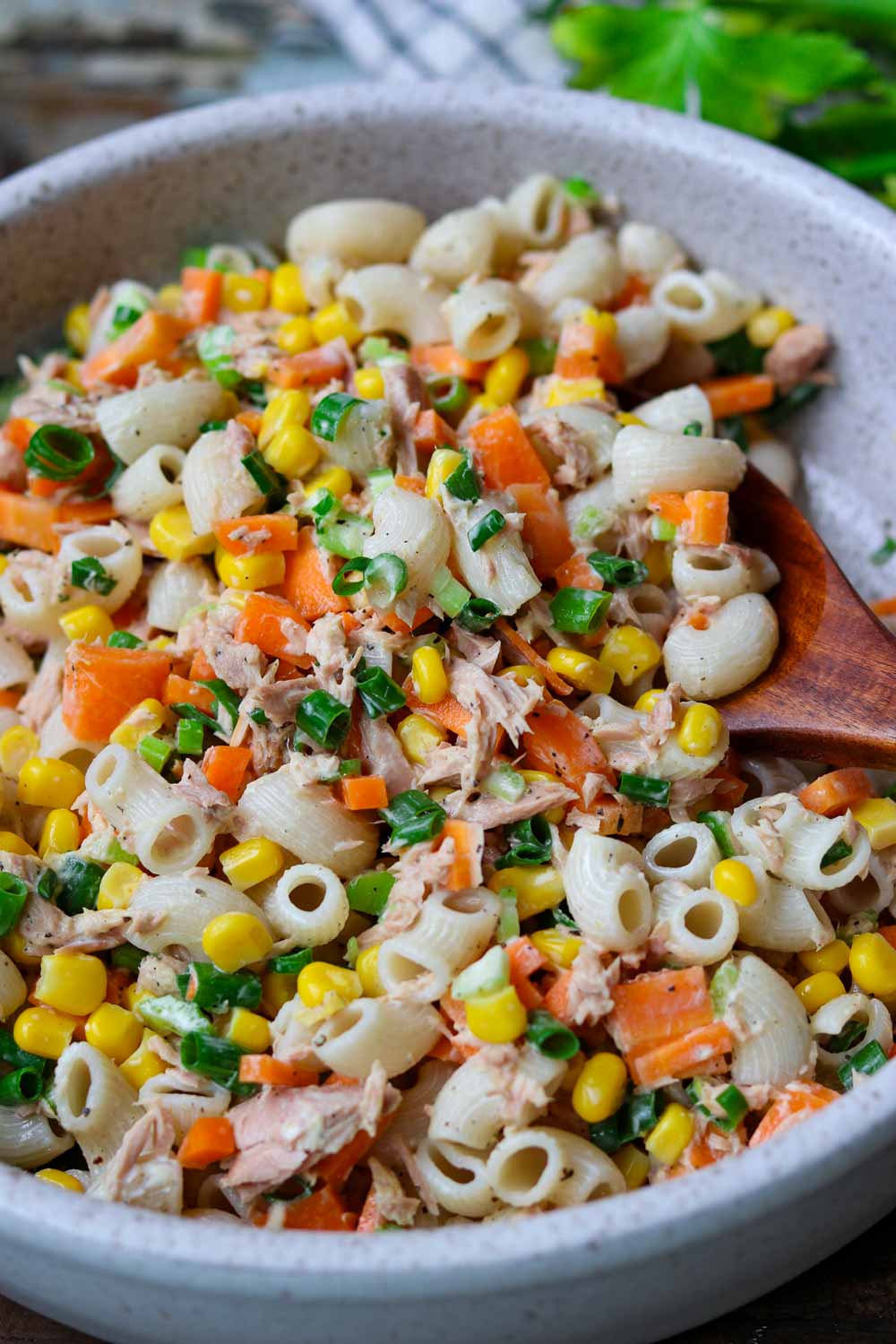 nudelsalat mit thunfisch, mais, möhren in einer hellen schüssel